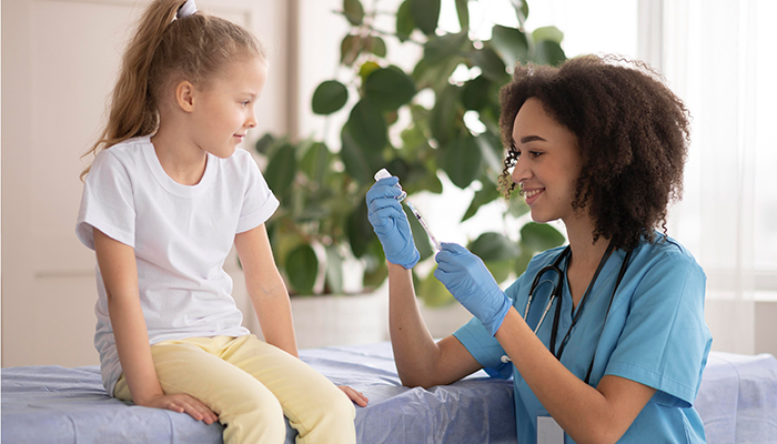 Health worker calms child down before giving administering a shot