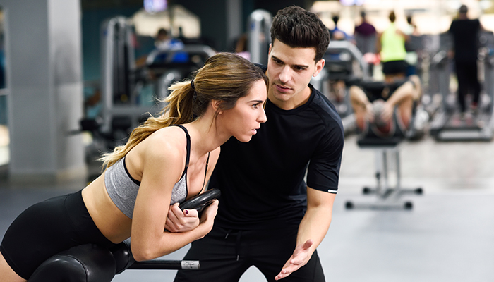 Personal Trainer works with client at the gym