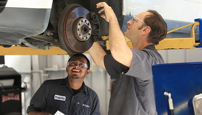 MPC Automotive students examine wheel hub during auto class