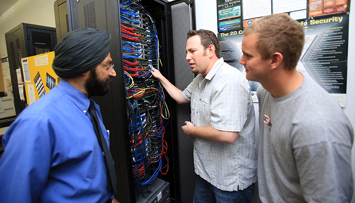 MPC Networking & Security faculty member works with students on a server rack