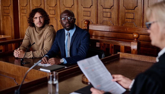 Lawyer and Client Listening to Judge Issuing Court Order