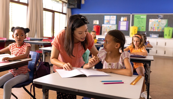 Elementary School Teacher Working with Students in Classroom