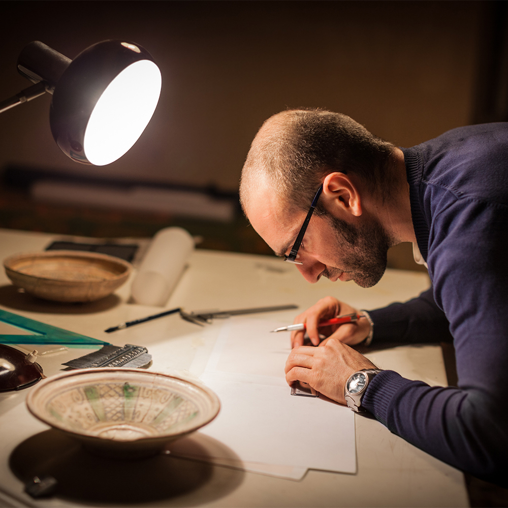 Historian/Archeologist studies ancient pottery