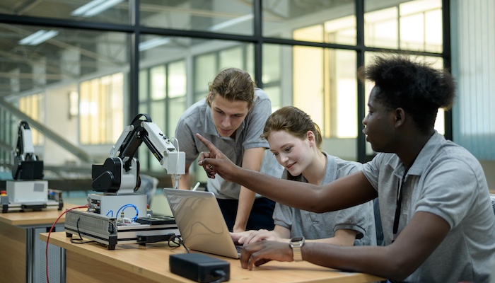 Three Engineering Students Working Together on Project in Class