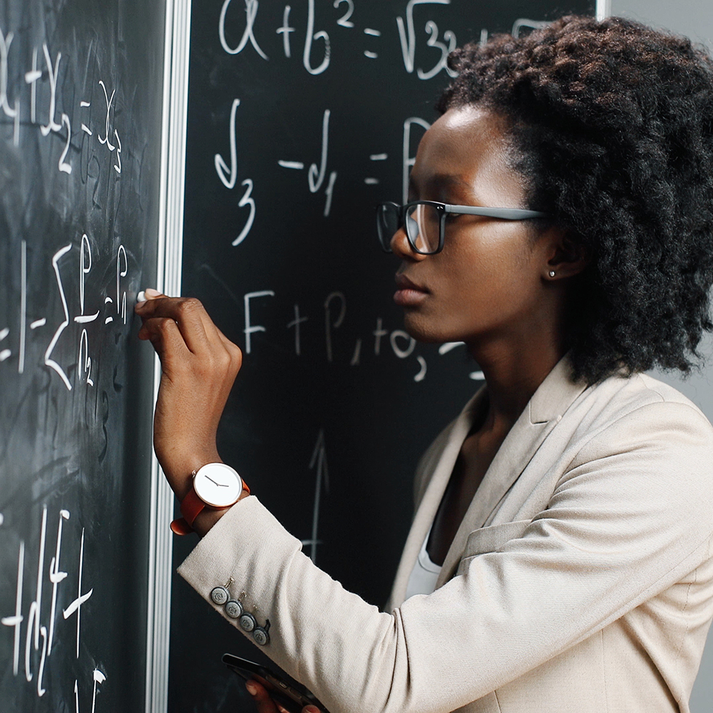 Professor working on equation in mathematics class