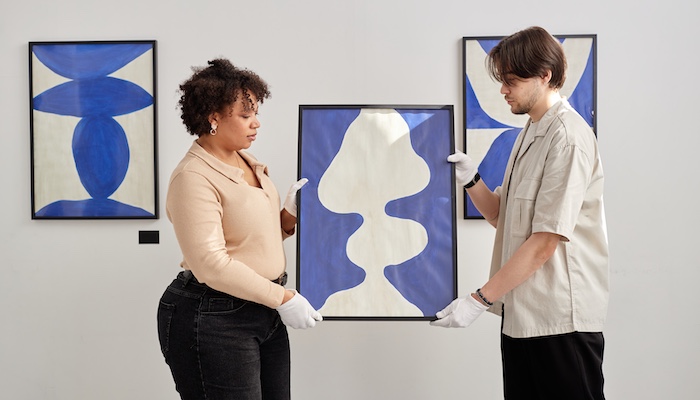 Two People Holding Painting Preparing Art Gallery Exhibition