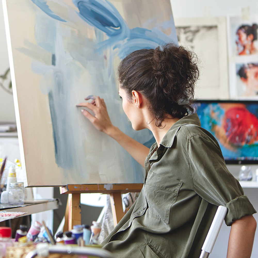 Art student works on painting in an art studio