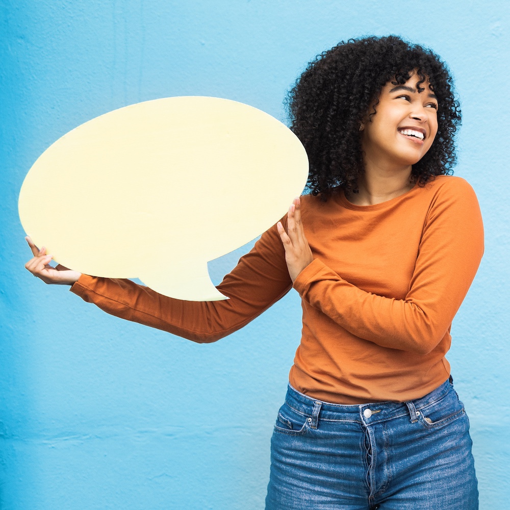 person holding speech bubble and smiling