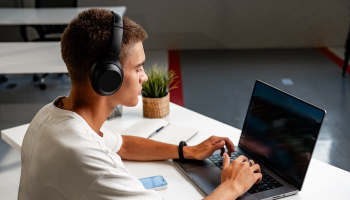 Person with Headphones Working on Laptop