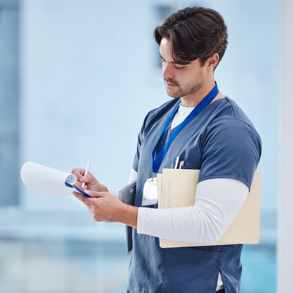 Medical Assistant Writing on Clipboard