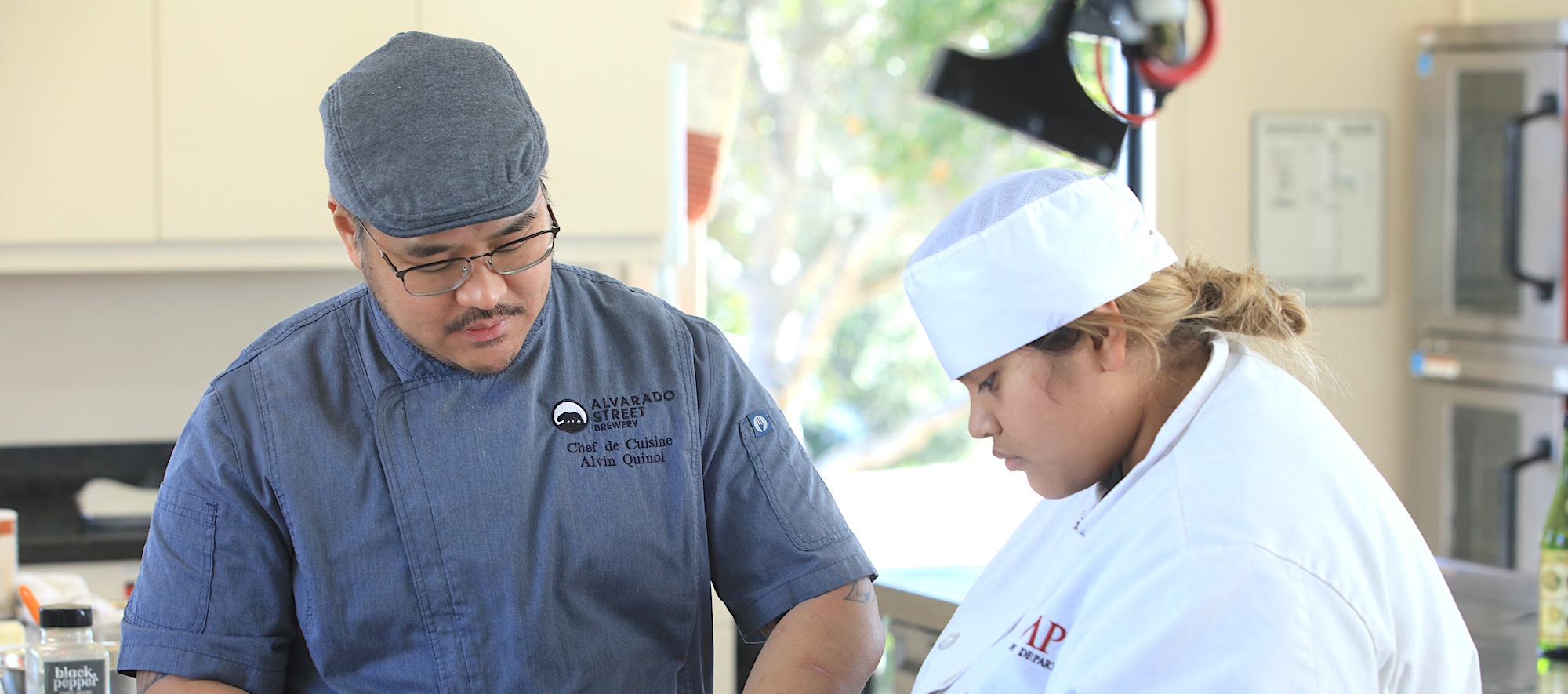 Hospitality Instructor Assisting Student in Hospitality Class