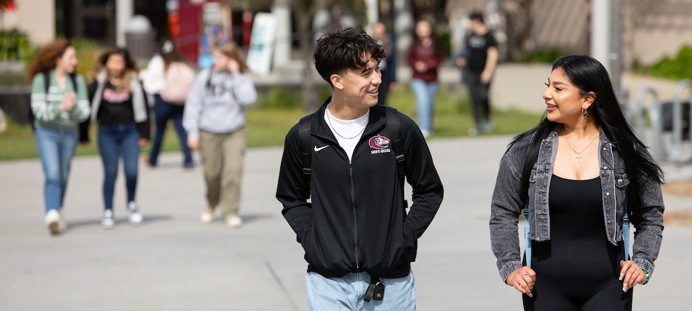 Two Students Walking on MPC Monterey Campus with Additional Students Walking in the Background