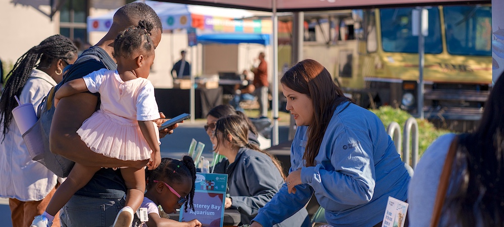 Person Tabling and Speaking to Parent with Children at Family STEM Day