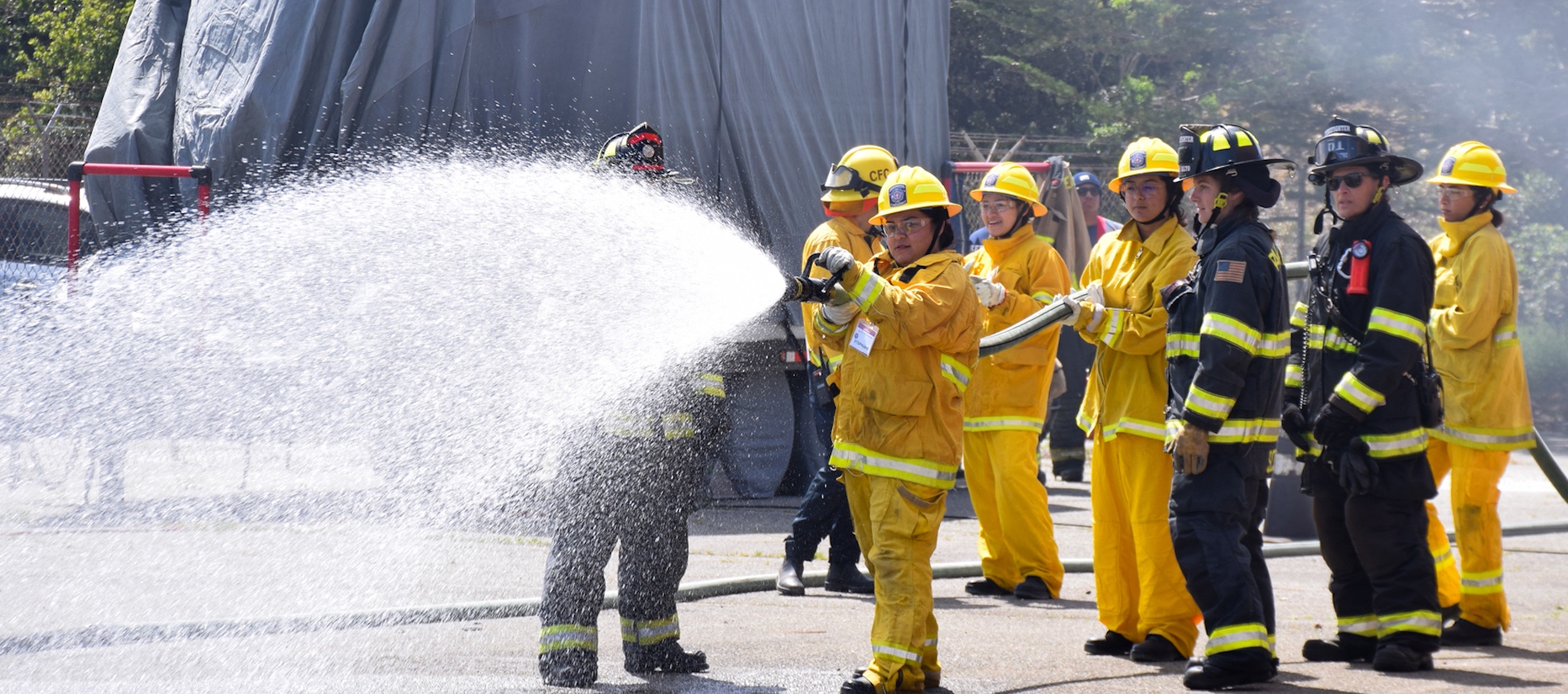 firls firefighter camp practicing using the fire hose