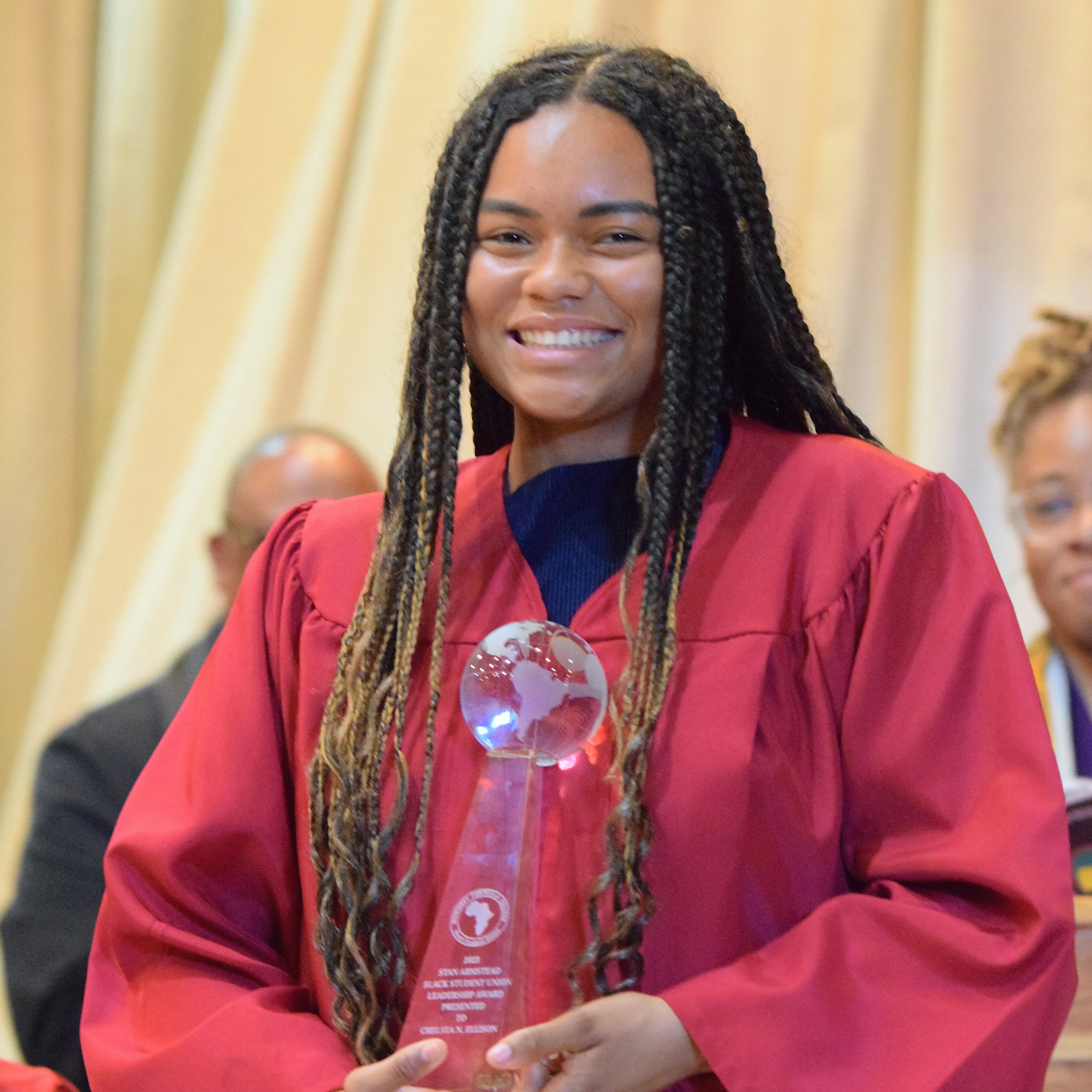 Student Holding Award at Rites of Passage Graduation Event