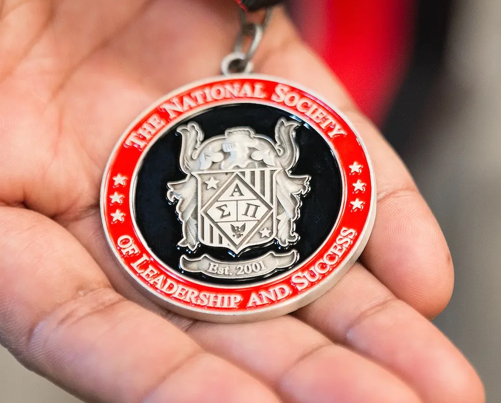 Hand Holding Medal for National Society of Leadership & Success