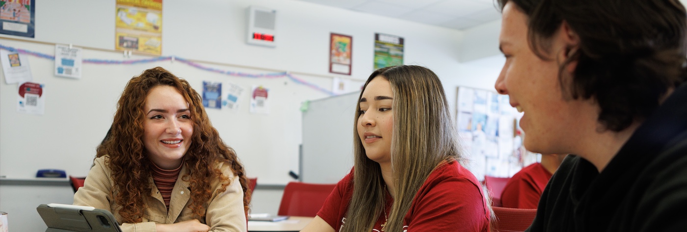 Three Students Discussing in Tutoring Center